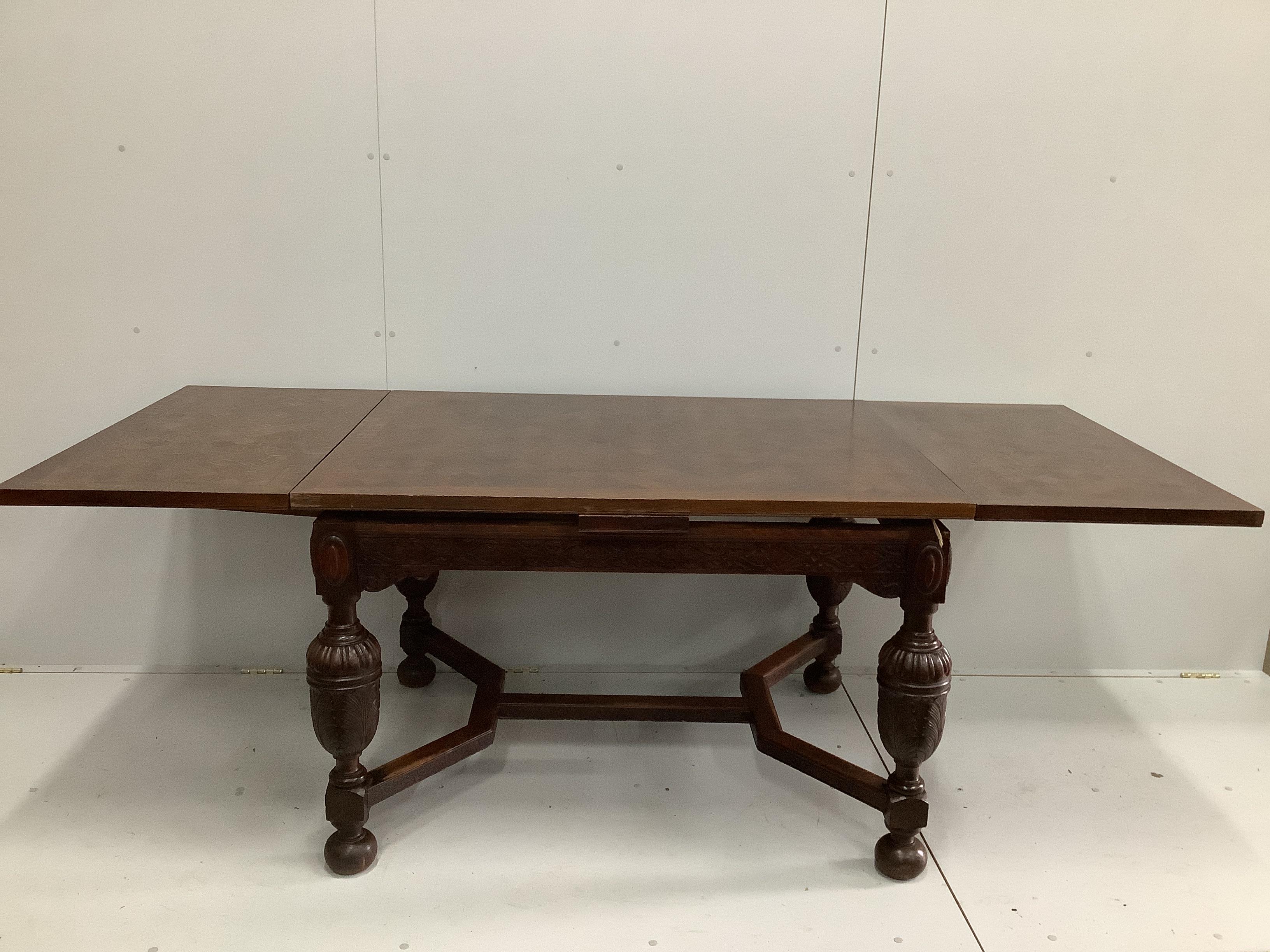 A Jacobean Revival parquetry inlaid rectangular oak draw leaf dining table, 220cm extended, depth 94cm, height 78cm together with six 1920's oak dining chairs, two with arms